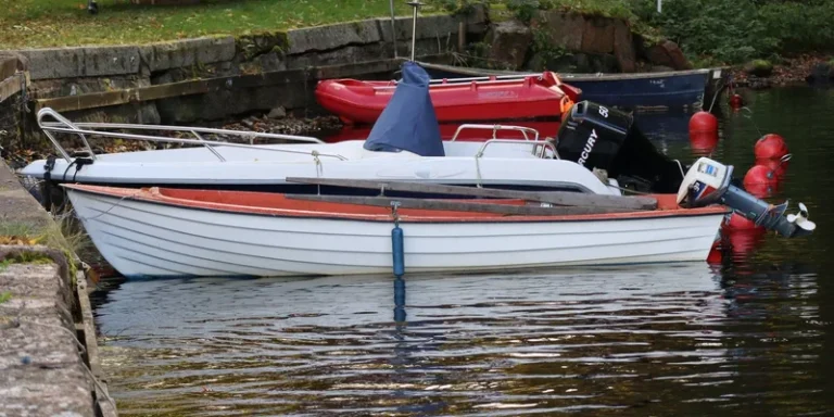 A docked motorboat featuring a Mercury engine near the riverside, surrounded by red buoy markers
