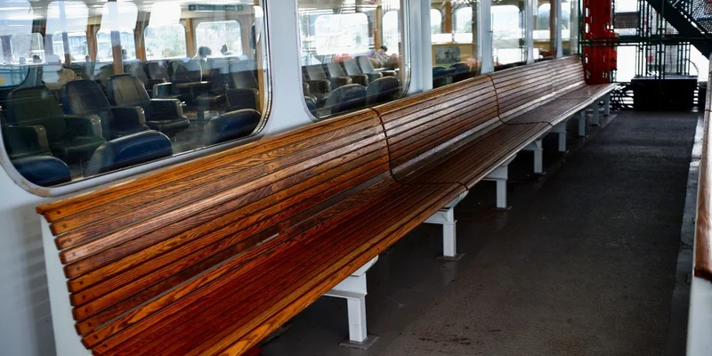 Empty ferry deck with wooden benches and indoor seating area