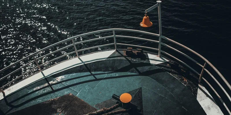 High angle view of a ship's deck with steel railings above the ocean