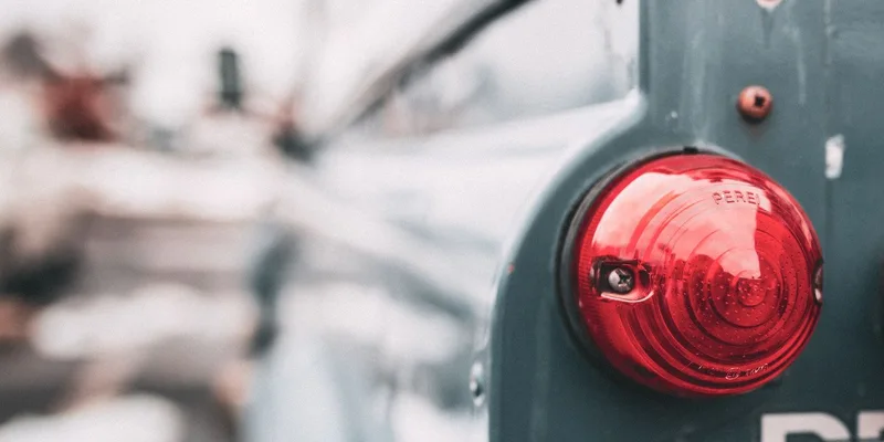 Detail of a vintage vehicle's red tail light showcasing classic design elements