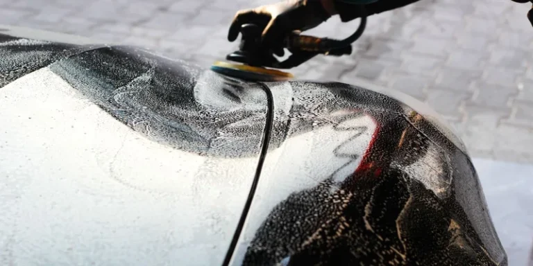 Close-up of a car being polished by hand