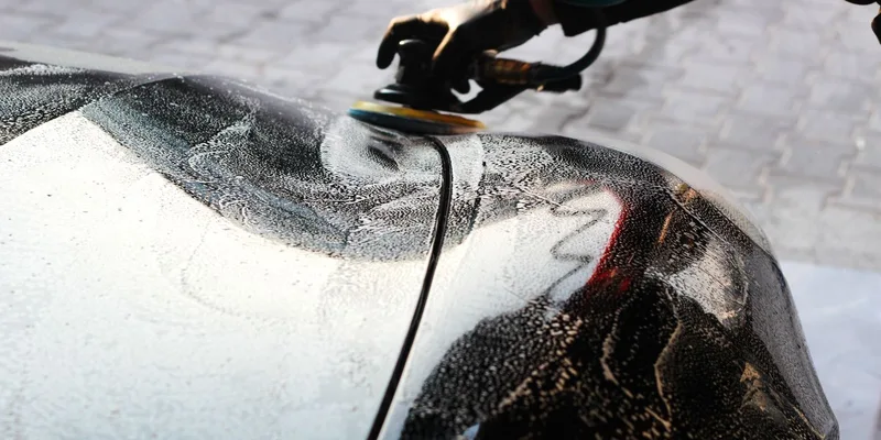 Close-up of a car being polished by hand
