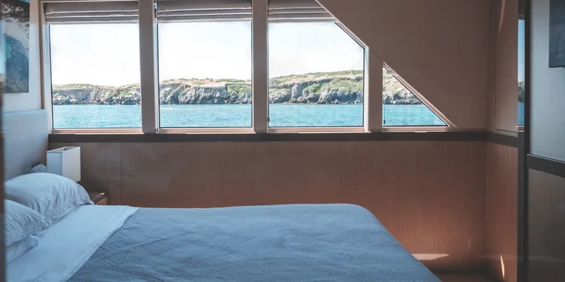 A tranquil yacht cabin interior with ocean views through large windows