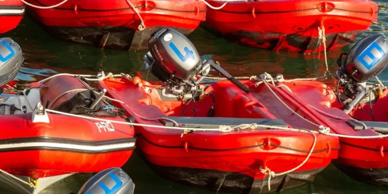 Docked red inflatable boats equipped with outboard motors, ready for use on the water