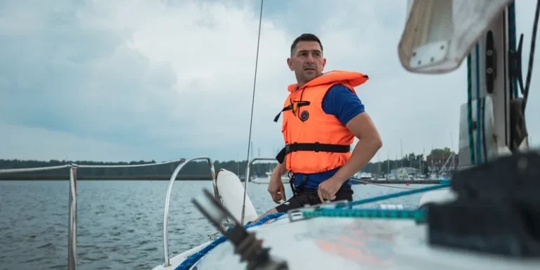 A man in a life vest sailing on a lake
