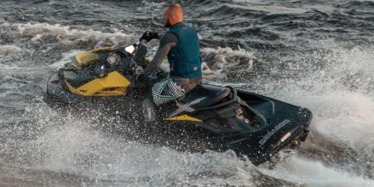 A man wearing a life vest rides a jet ski across choppy waters