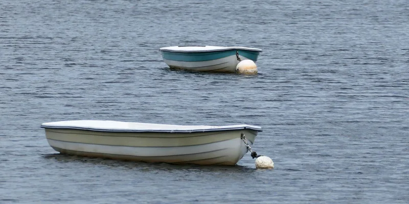 Two rowboats floating peacefully on a lake