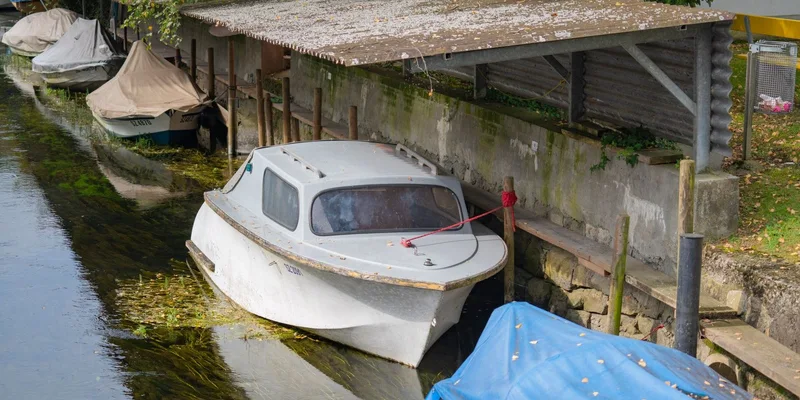 Covered boats moored along a calm canal