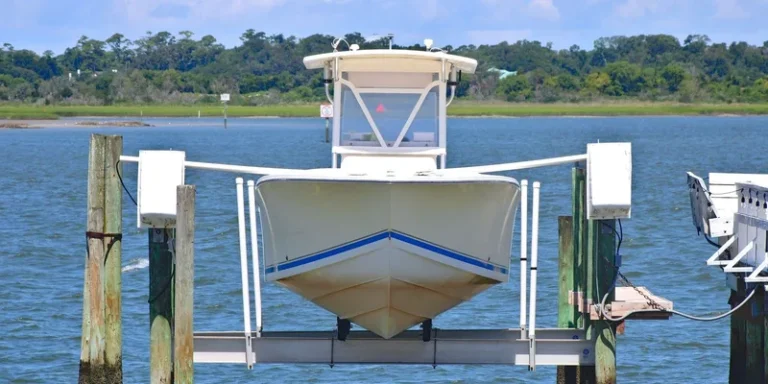 White boat lifted on dock with scenic waterway and lush greenery in the background