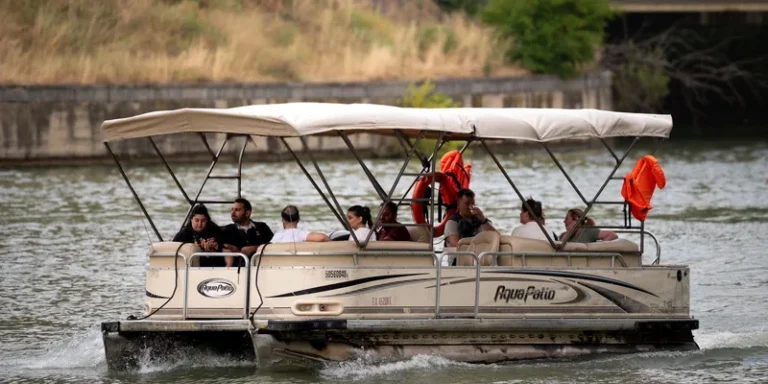 Pontoon boat cruising on a river with diverse passengers enjoying a sunny day in Tbilisi