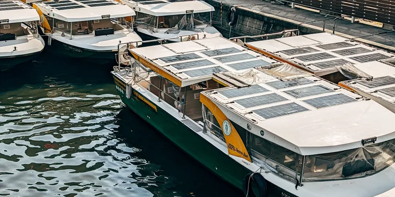 A fleet of solar-powered boats docked at an urban marina