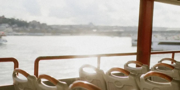 Empty seats on a boat overlooking a calm water view under bright sunlight