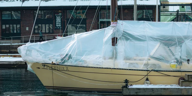 A covered yacht at a snowy dock in Toronto